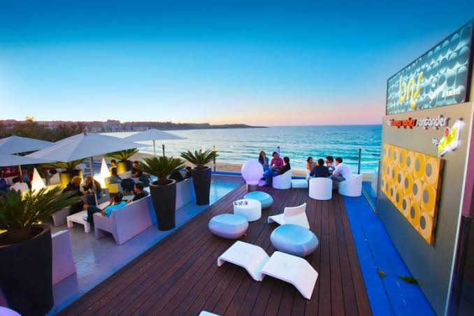 Playa de El Sardinero en Santander vista desde una terraza urbana al anochecer con luces de la ciudad