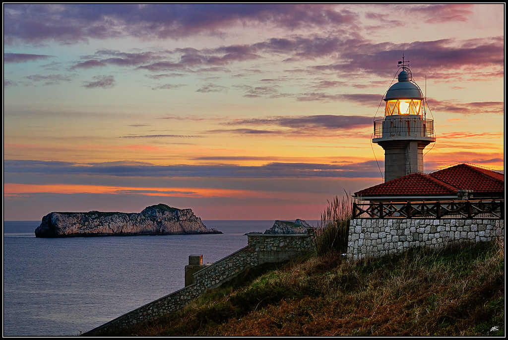 Faro de Punta del Torco de Afuera en Suances sobre el acantilado, vista lateral desde el paseo marítimo