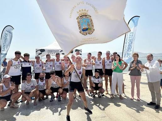 Público animando desde el paseo marítimo de Santander durante una regata de traineras, banderines y ambiente de fiesta junto al agua.