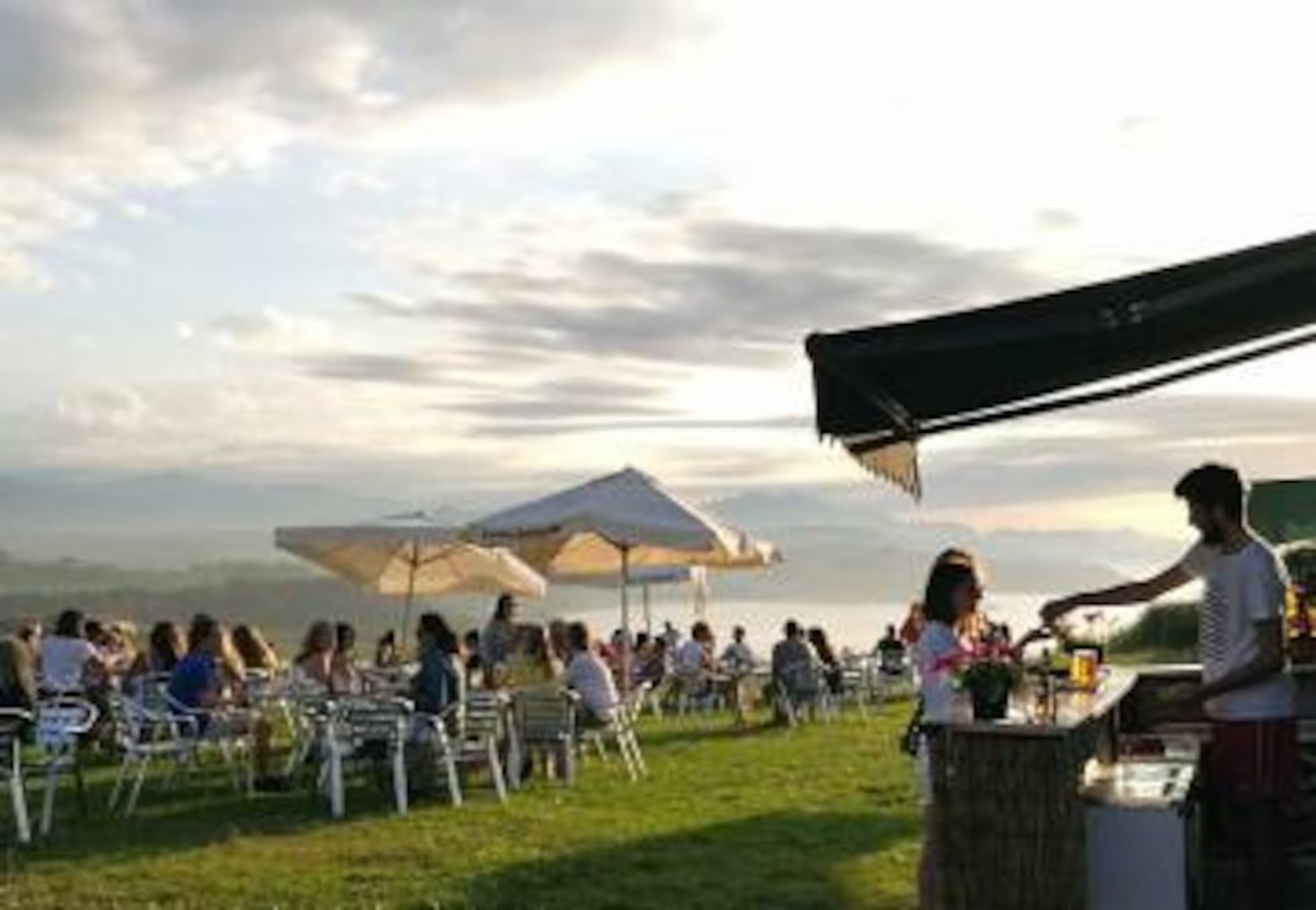 Terraza de un restaurante con vistas al mar en la costa de Cantabria, comensales en verano