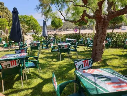 Familias comiendo raciones en la terraza de Chiringuito La Arena, a pie de la playa de la Arena, Isla