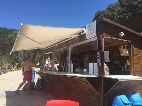 Barra de madera sencilla del Chiringuito La Huella con vistas a la arena de la playa de Galizano