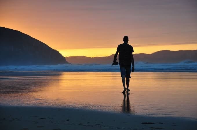 Atardecer en la playa de Merón, marea baja, silueta de las dunas a contraluz.