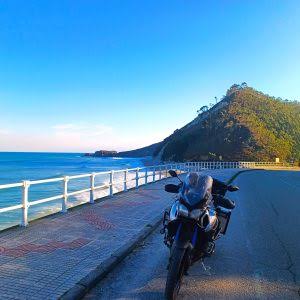 Moto de carretera aparcada junto a un mirador de la costa cántabra, día soleado