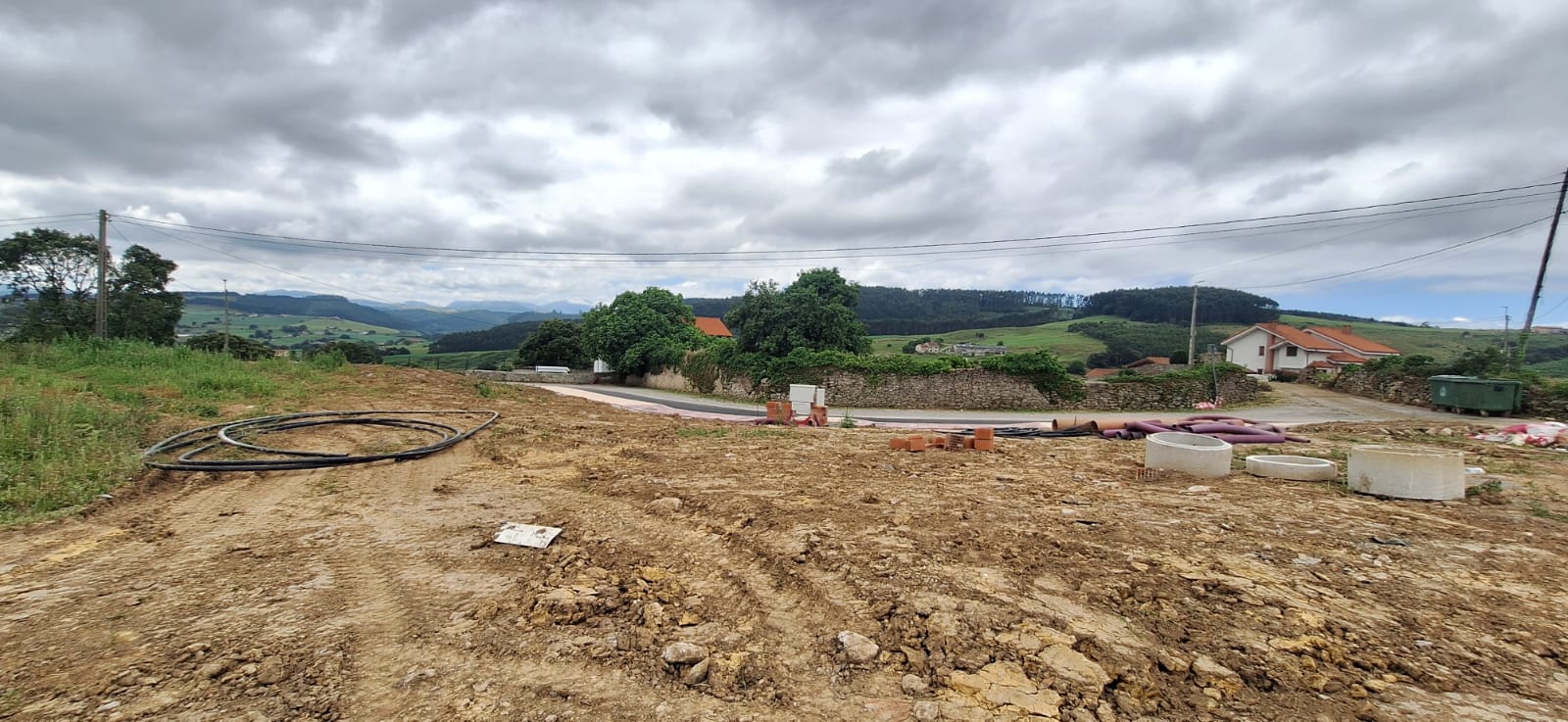 primer tramo de acera pavimentada junto a la carretera, montañas de fondo