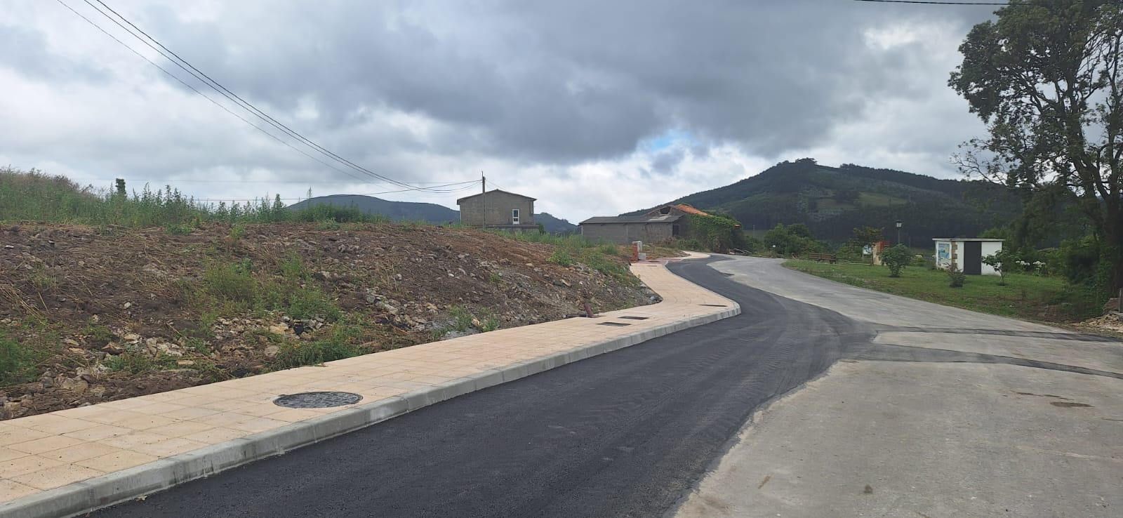 tuberías enrolladas y arquetas sobre tierra removida, campiña de Bareyo al fondo