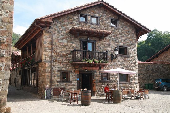Fachada o comedor de La Solana en Bárcena Mayor, con el pueblo de piedra al fondo