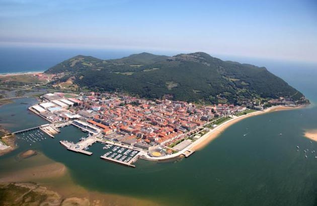 Monte Buciero visto desde el puerto pesquero de Santoña, barcos en primer plano.
