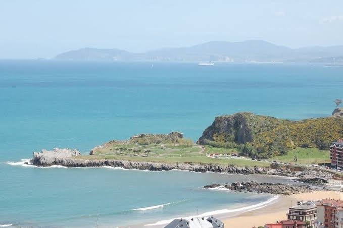 Playa de Brazomar en Castro-Urdiales con el castillo-faro de Santa Ana al fondo