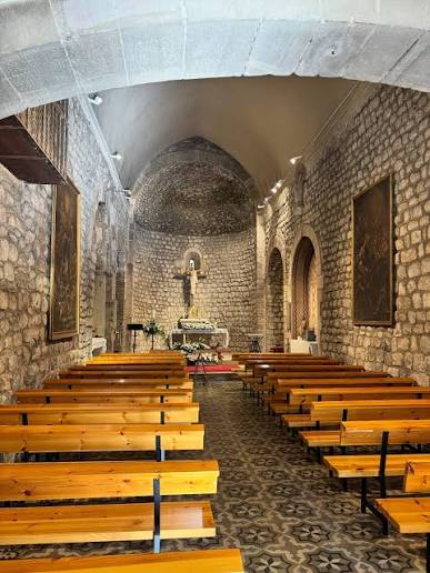 Interior en piedra de una iglesia románica rural de Cantabria, arco de medio punto y luz natural
