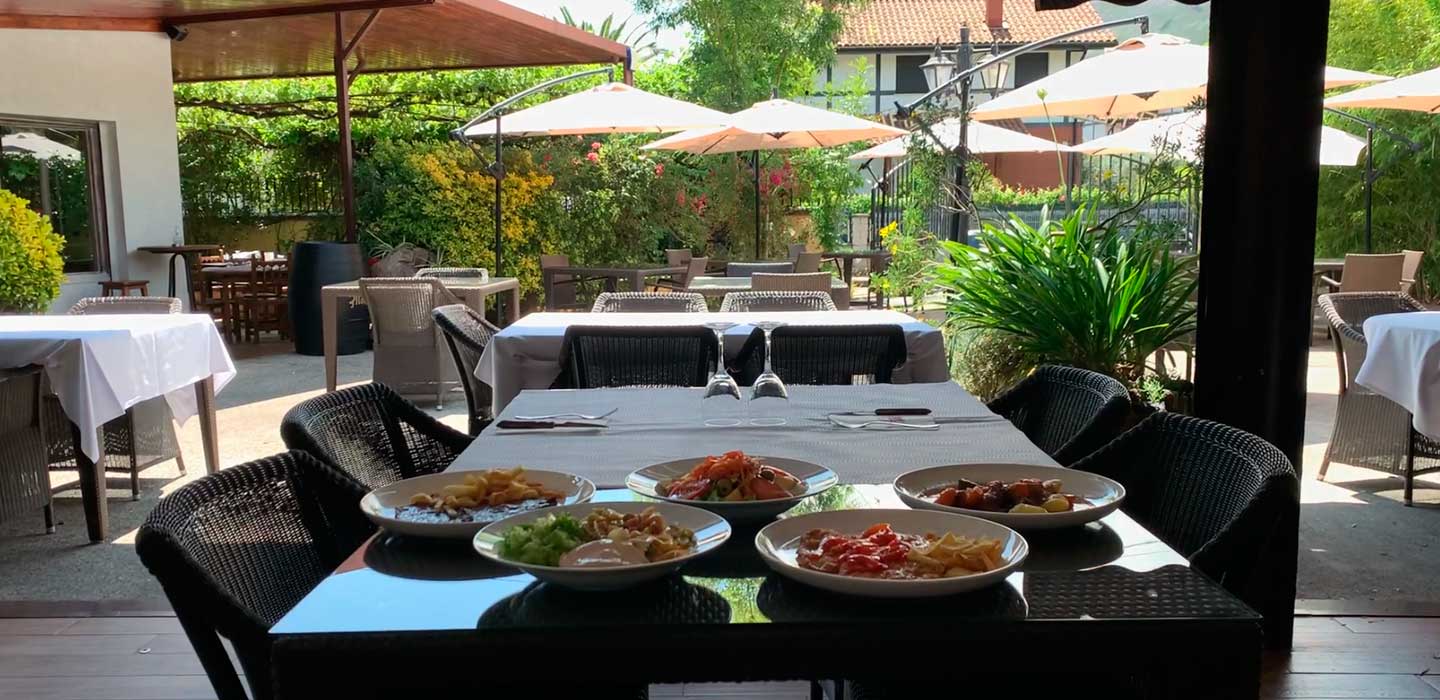 Terraza de un restaurante tradicional cántabro con comensales, ambiente informal de mediodía.