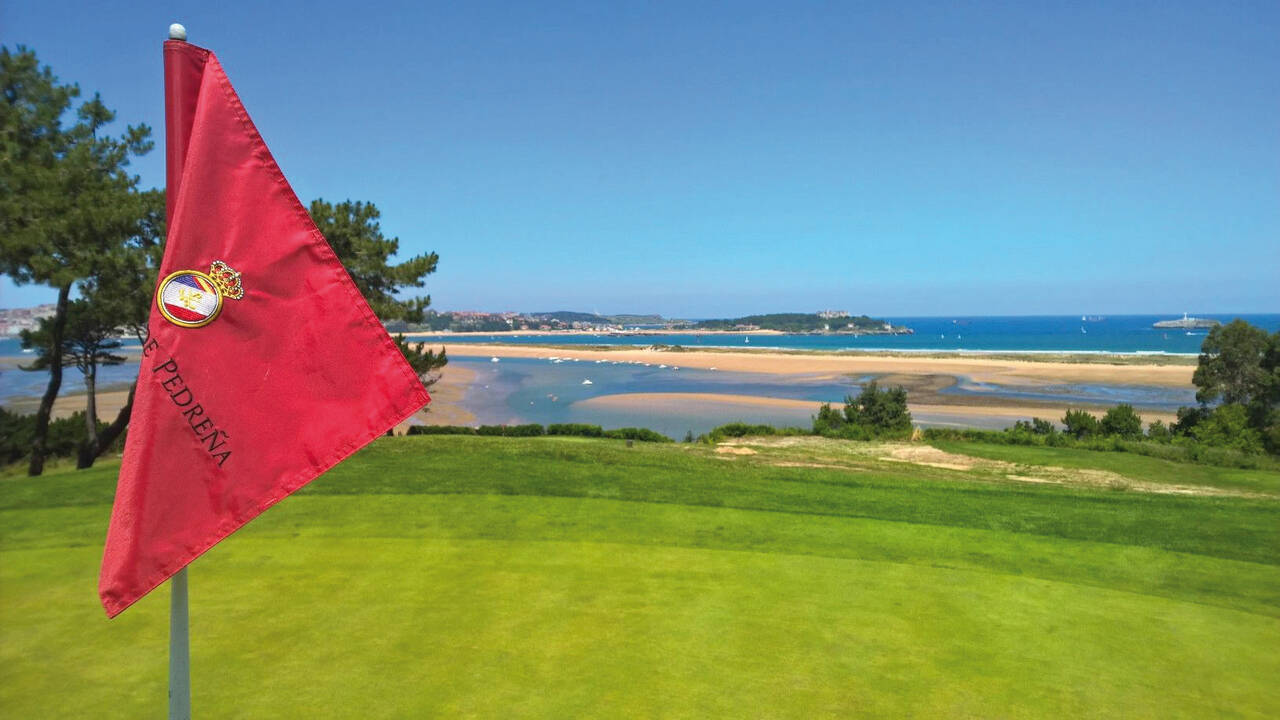 Green del Real Golf de Pedreña con vistas a la Bahía de Santander y siluetas de los Picos de Europa al fondo