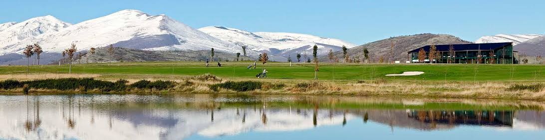 Calle del campo de golf de Nestares con el macizo nevado de Alto Campoo asomando al fondo