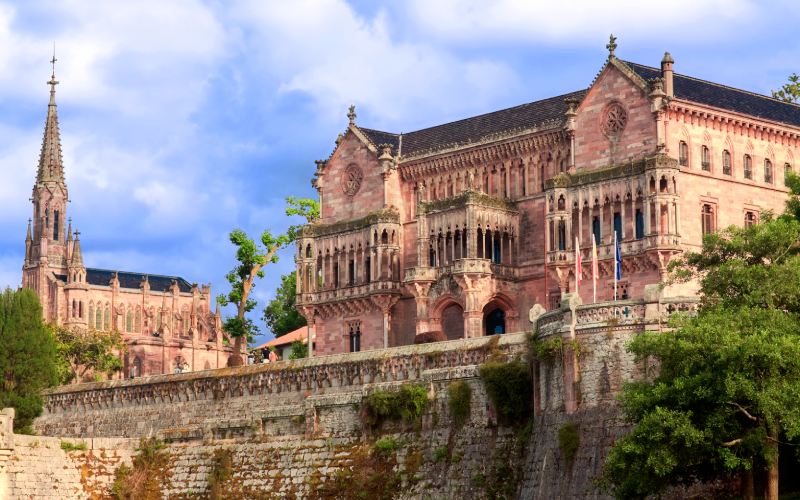 Fachada neogótica del Palacio de Sobrellano en Comillas con la Universidad Pontificia al fondo