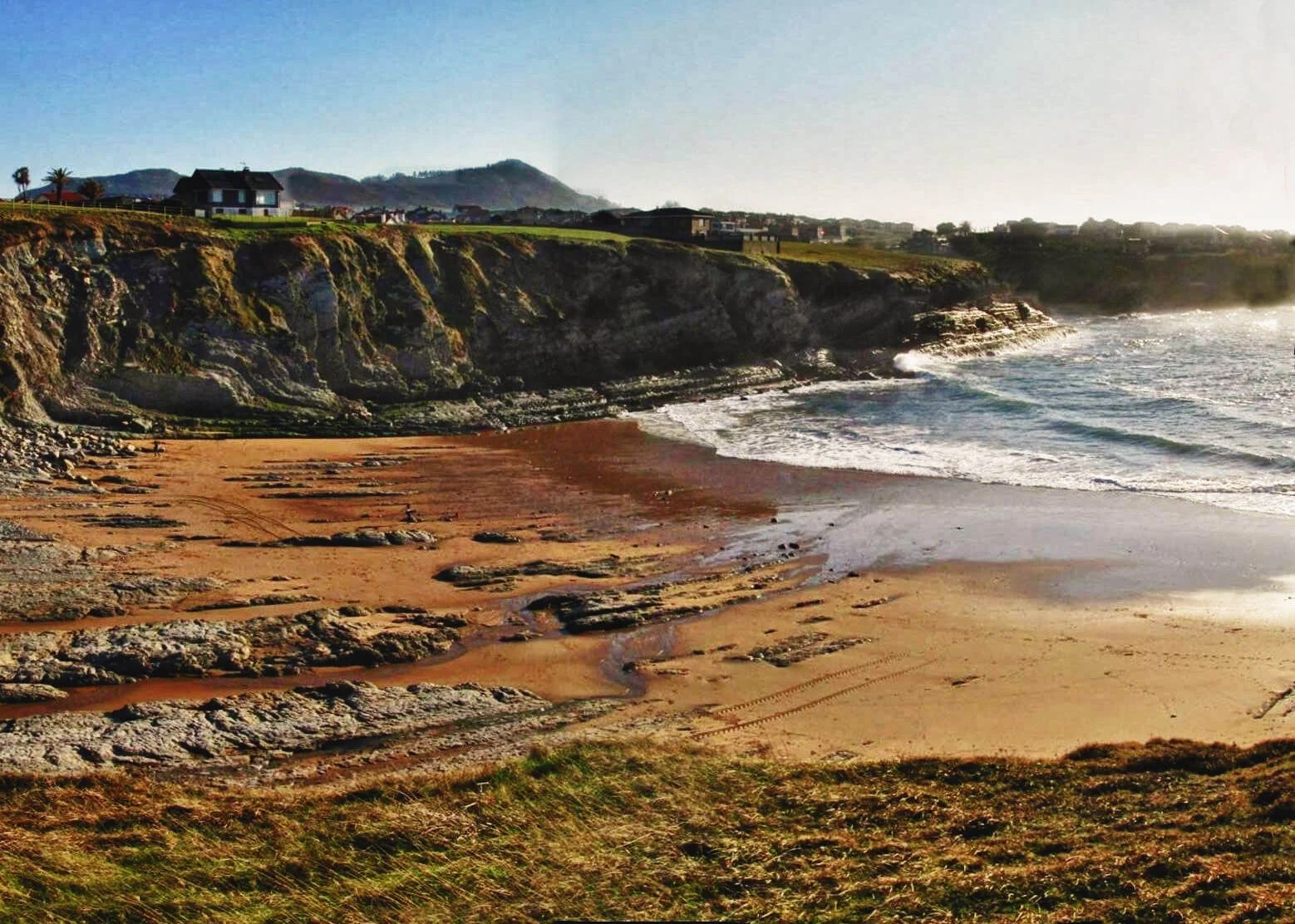 Cala estrecha de la Playa de Portío encajada entre acantilados, marea baja
