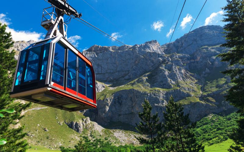 Cabina del teleférico de Fuente Dé ascendiendo hacia la estación de El Cable, con el macizo central de los Picos de Europa al fondo.