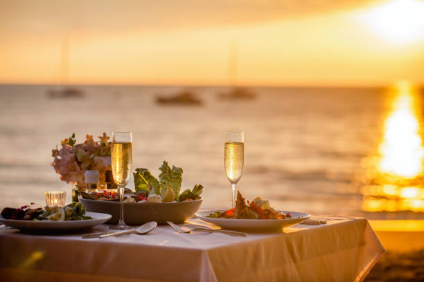 Mesa para dos con vistas al mar, copa de vino, ambiente íntimo
