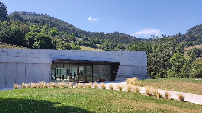 Entrada al Centro de Arte Rupestre de Cantabria en Puente Viesgo, con el paisaje de montaña al fondo