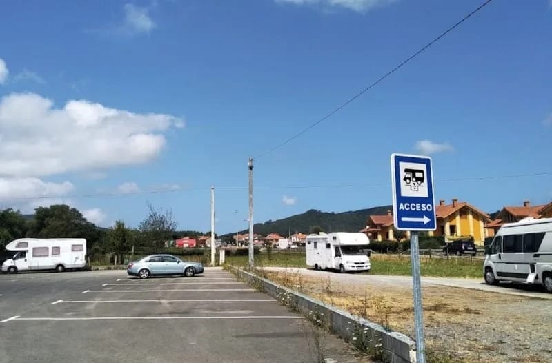Área de autocaravanas de Castillo Siete Villas en Arnuero, vehículos estacionados y punto de servicios.