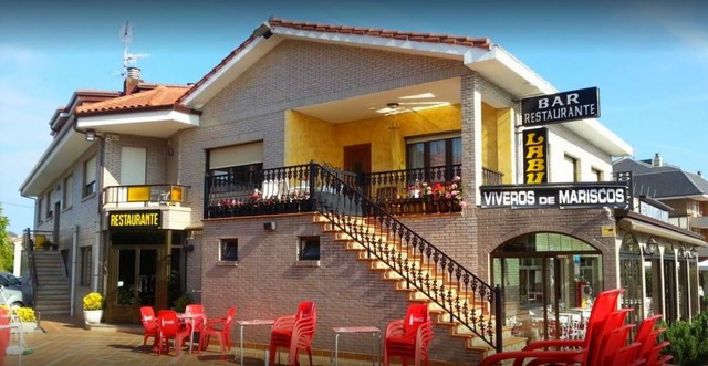 Fachada del Restaurante Labu en Ajo, con el comedor y el vivero de marisco a la vista