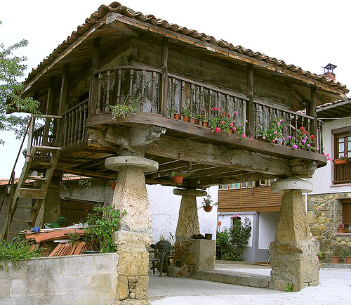 Hórreo o panera tradicional elevado sobre pilares de piedra en un prado de un pueblo del interior de Cantabria, entorno rural