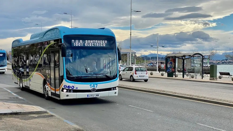 Autobús interurbano de línea regular esperando en una parada de carretera cántabra, con marquesina sencilla, día nublado.