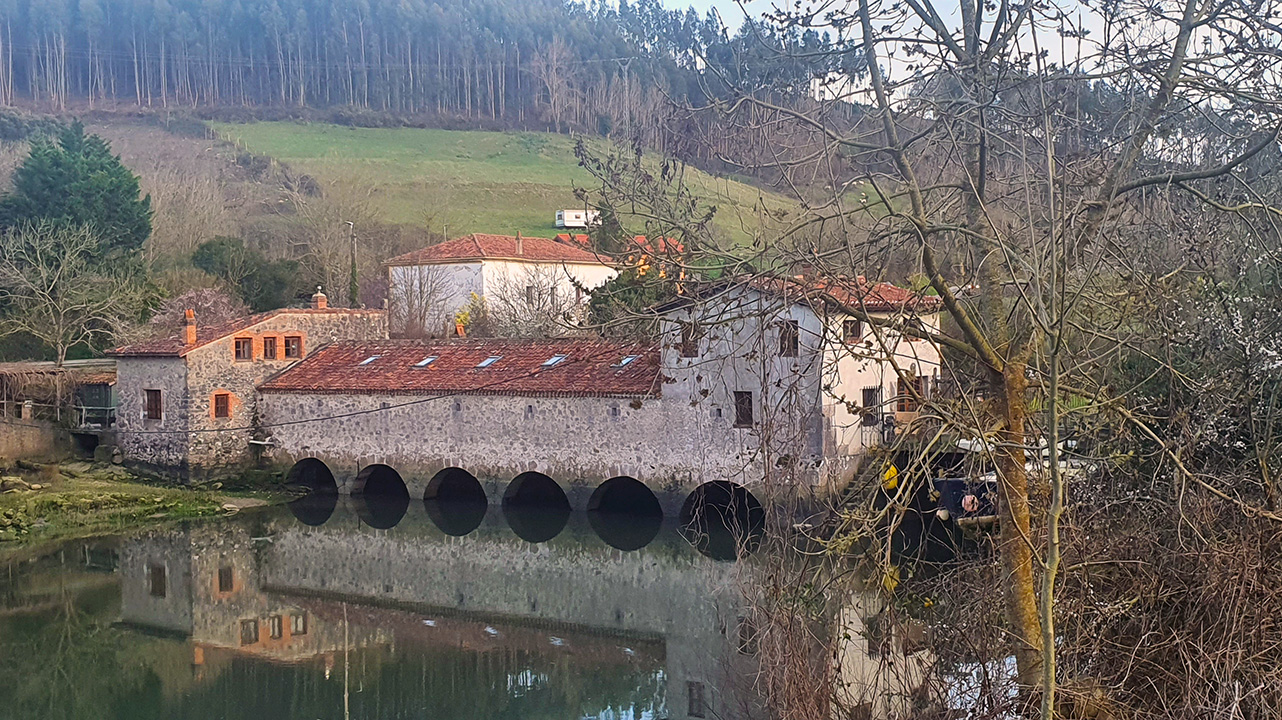 Molino de la Venera junto a la ría de Ajo, marea baja, detalle de la fachada de piedra