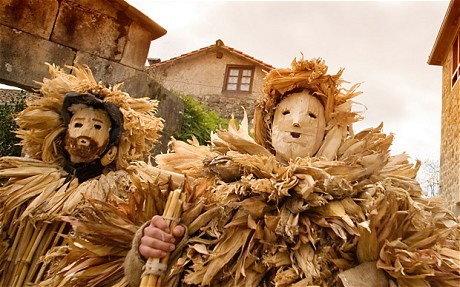 Foto de La Vijanera en Silió: personajes enmascarados del cortejo (el Oso, la Madama, los Trapajones) desfilando por la calle del pueblo el primer domingo de enero.