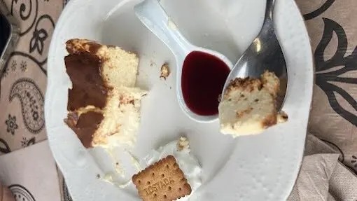 Tarta de queso entera servida en mesa al estilo casero en Llanda Bar & Café, Tagle, con el mar al fondo.
