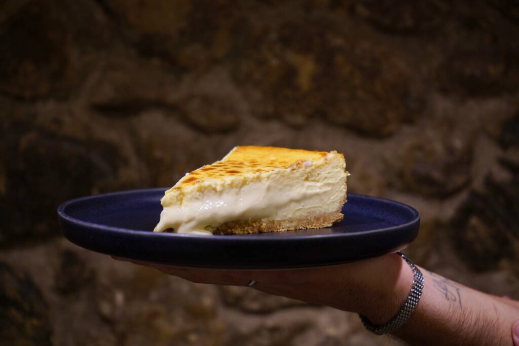 Mostrador del obrador La Quesona con tartas de queso enteras expuestas, ambiente de pastelería.