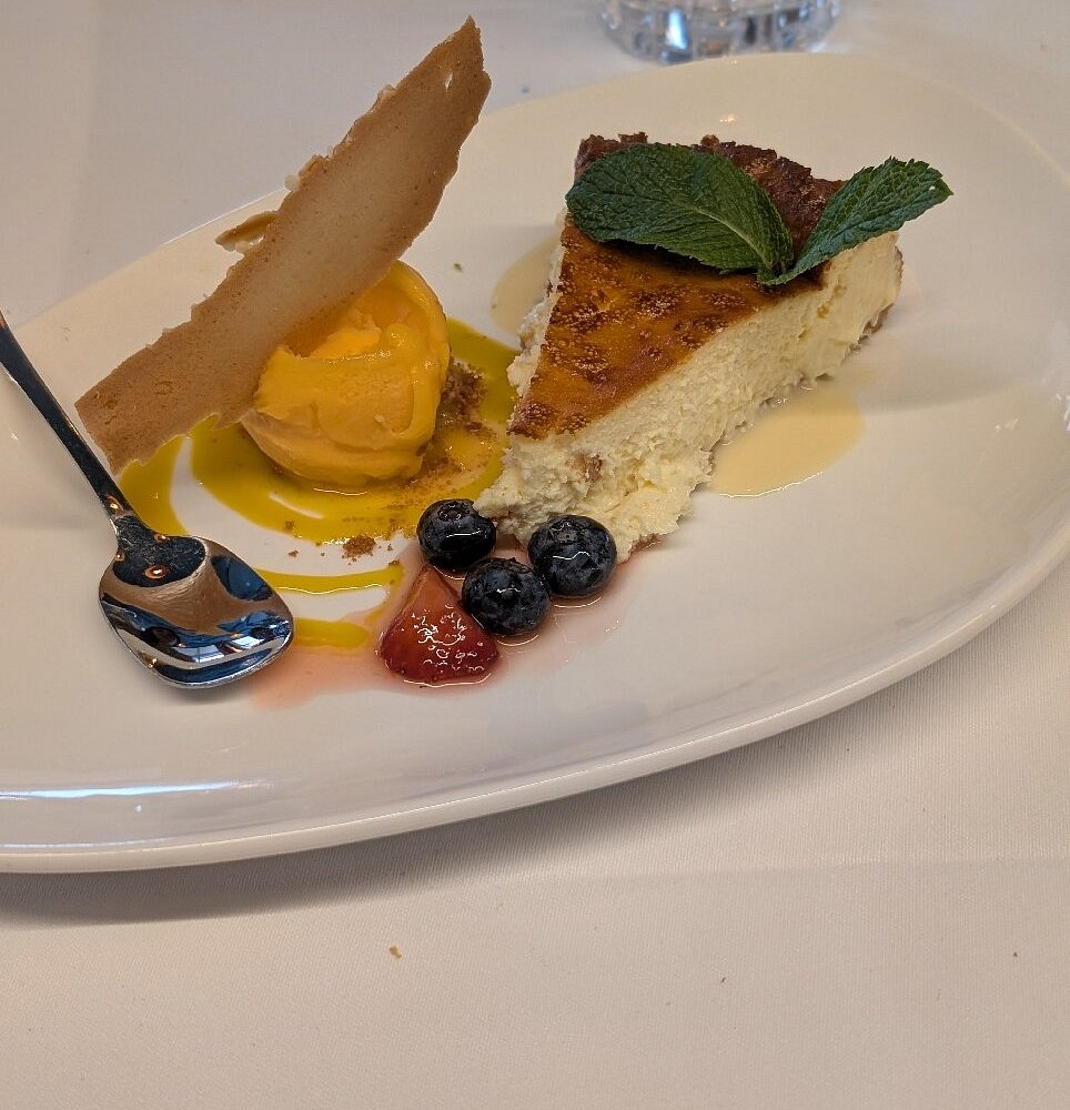 Barra rústica de The Hunter's Tavern en Entrambasaguas con una porción de tarta de queso sobre tabla de madera.