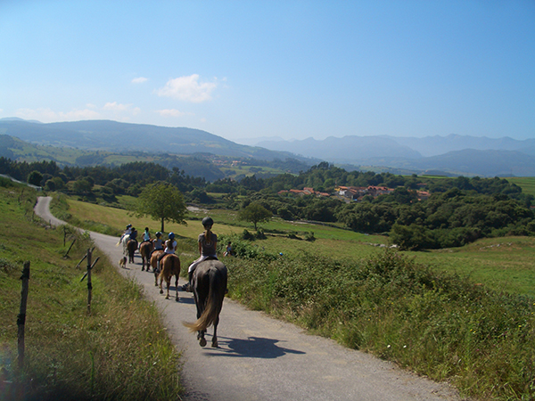 Paseo a caballo en la finca de la Posada de Ajo, en Bareyo, con el mar de fondo