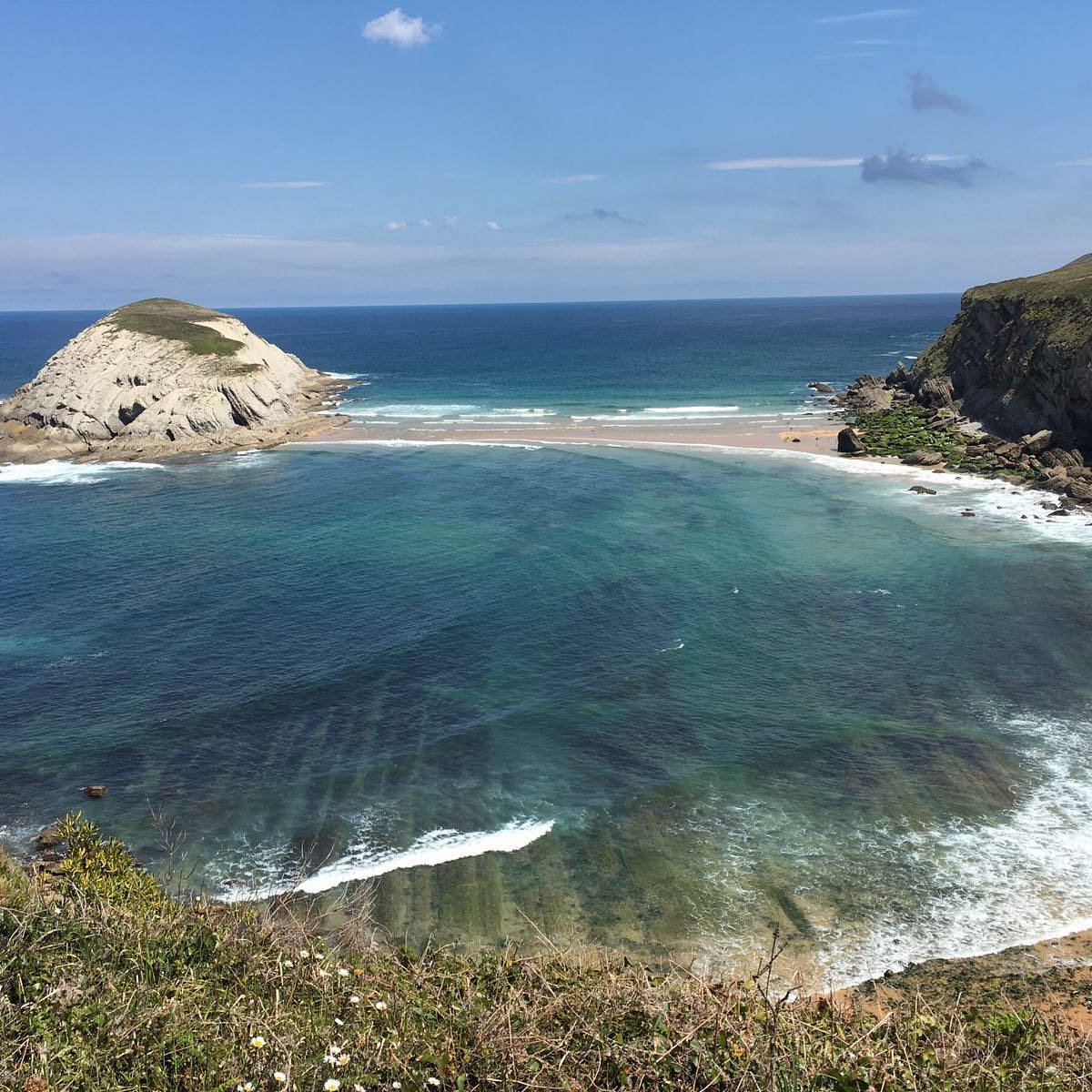 La ermita de la Virgen del Mar sobre su islote con el tómbolo de arena visible en marea baja, Santander