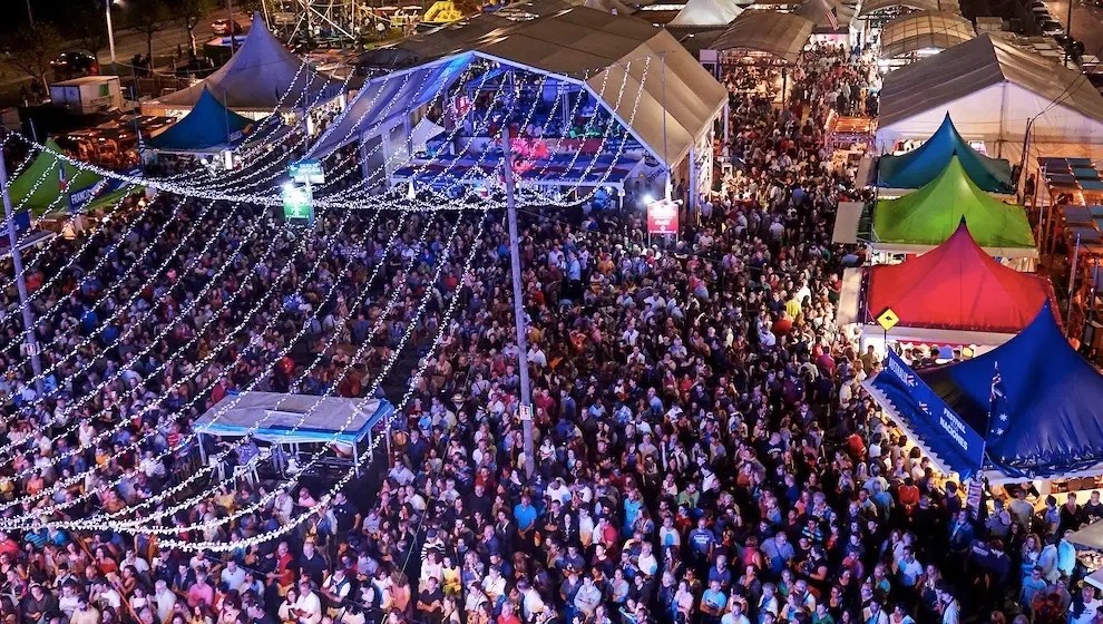 Escenario principal del Festival Intercultural de las Naciones con actuación de danza y público, ambiente nocturno