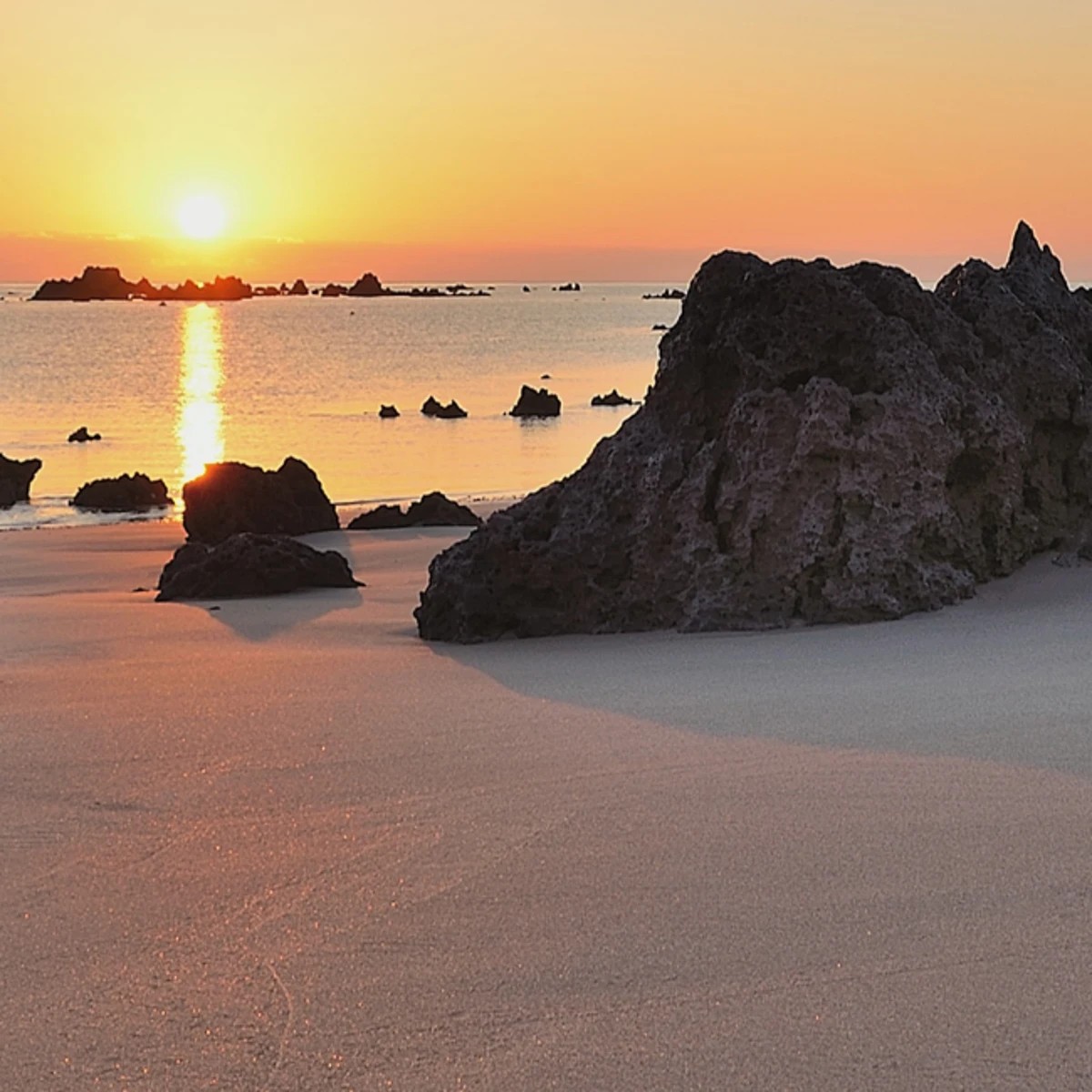 Playa cántabra casi vacía a finales de verano, marea baja dejando al descubierto una gran extensión de arena
