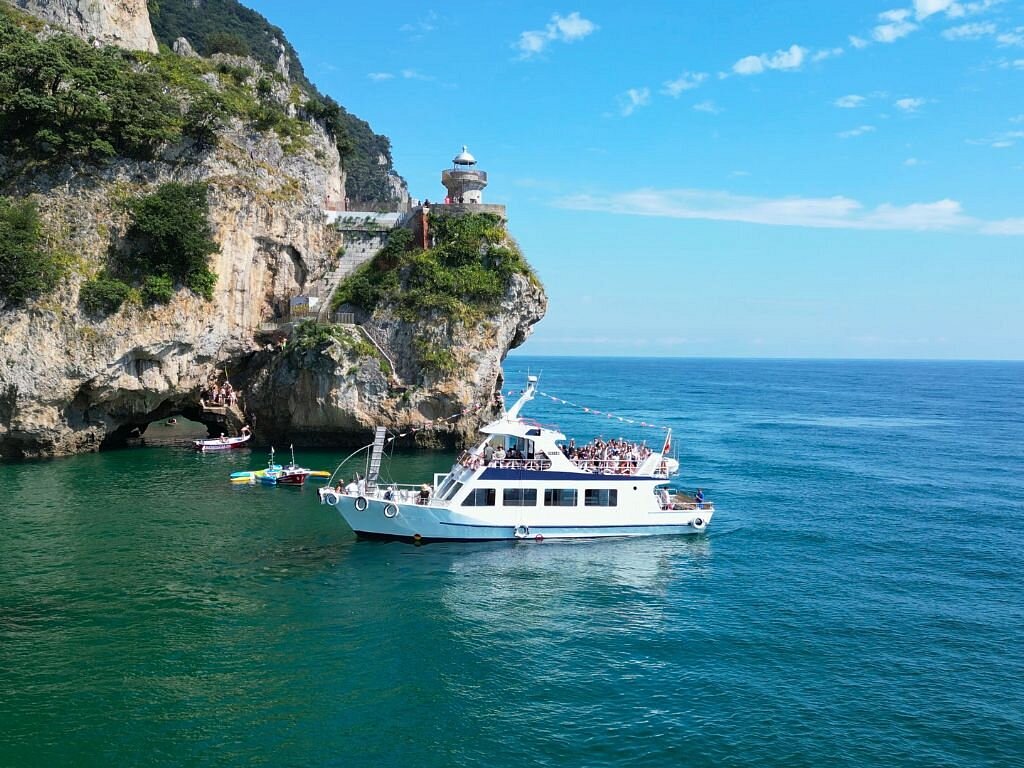 El Faro del Caballo visto desde el barco, con las Marismas de Santoña de fondo