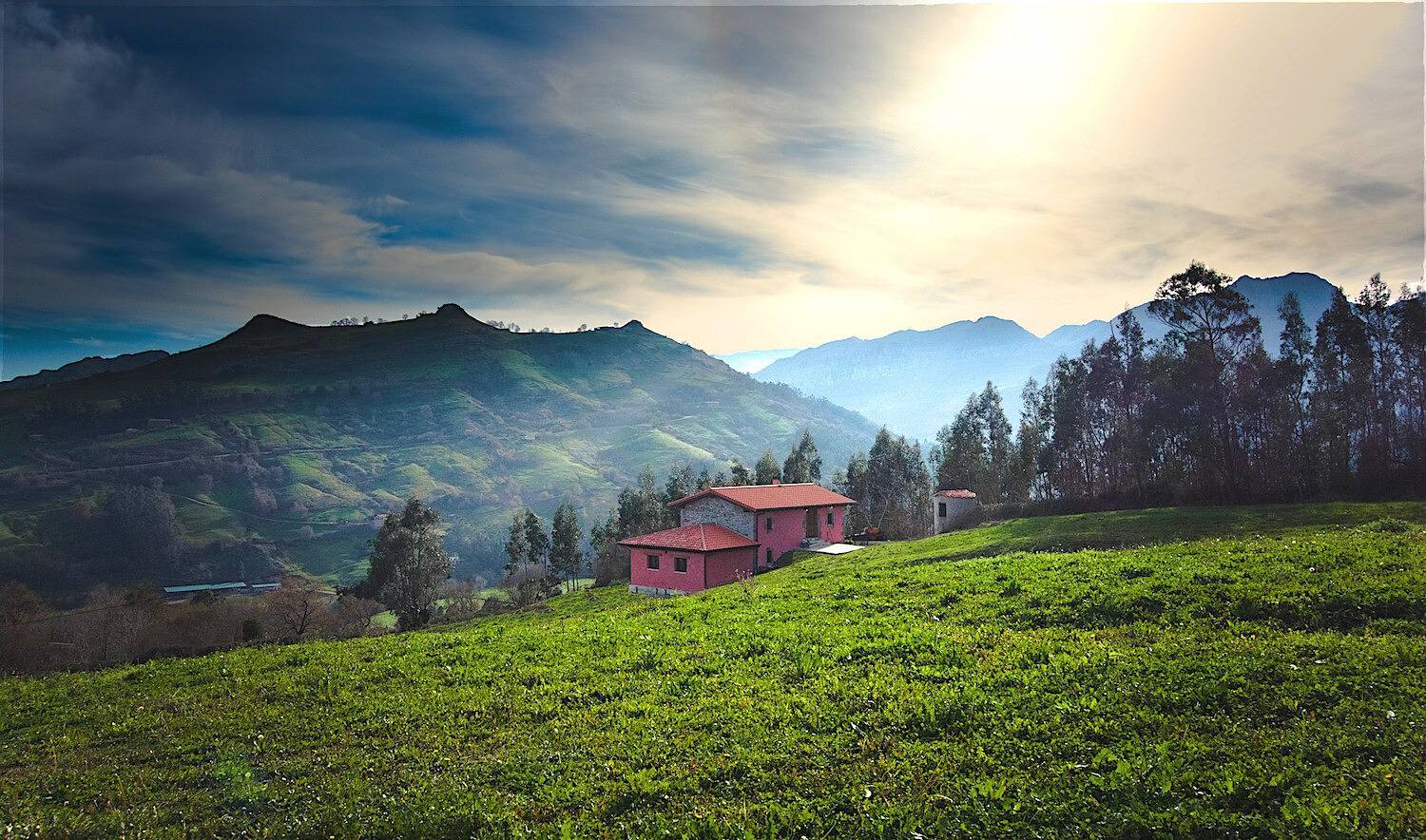 Paisaje rural de la Trasmiera cerca de Bareyo en otoño, prados y caseríos con niebla baja