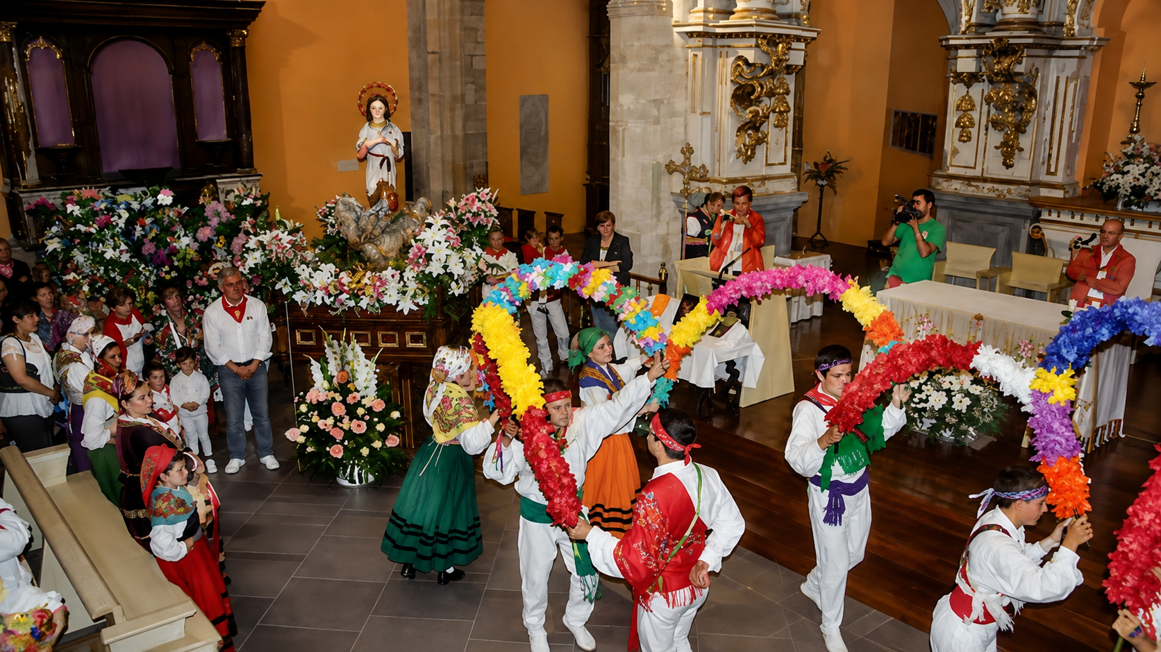 Ofrenda floral a la Virgen Niña frente a la iglesia de Santa María de Ampuero, con grupo de baile folclórico cántabro en la Plaza Mayor