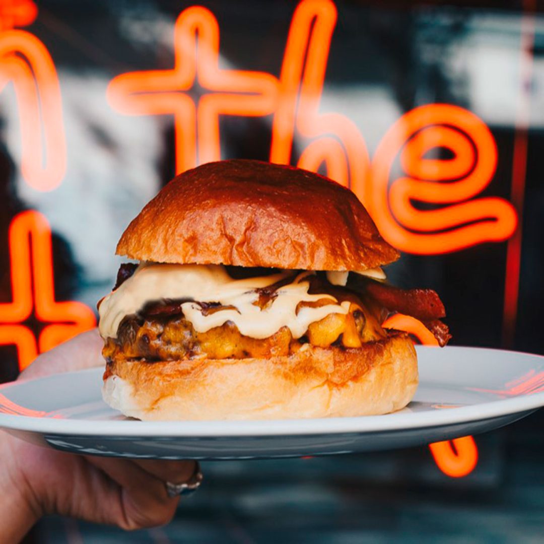 Interior del local La Carnaza Burger en Santander con la hamburguesa Jonny Cash en primer plano
