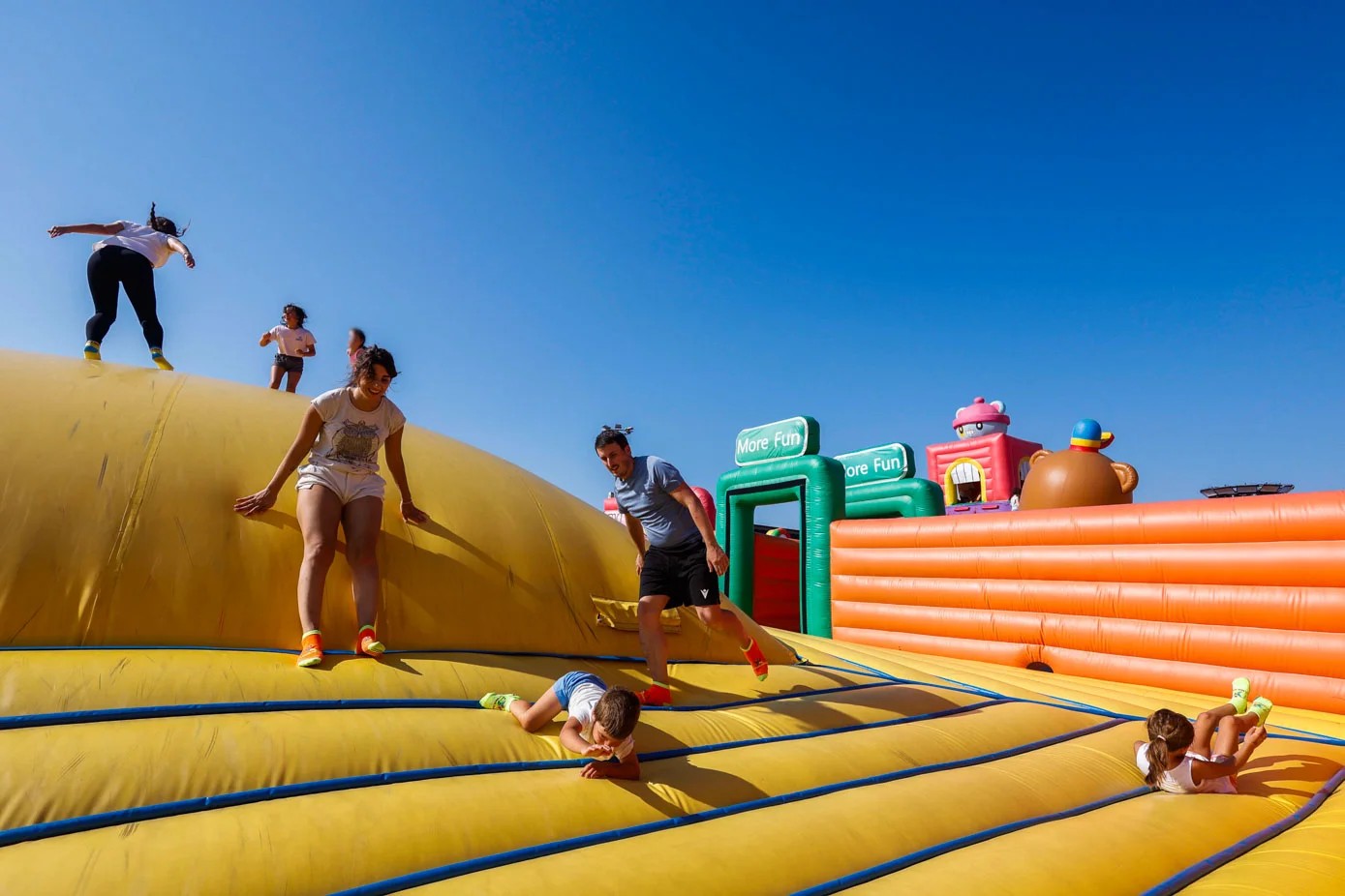 Familias con niños junto a atracciones hinchables en los jardines cercanos al Sardinero durante la fiesta