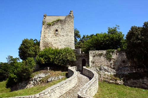 Torre de Estrada sobre roca con capilla anexa, rodeada de campo verde, en Val de San Vicente