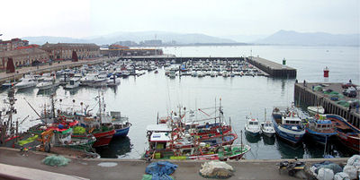 Muelle del Club Náutico de Santoña con embarcaciones de recreo amarradas, luz de primera hora de la mañana.