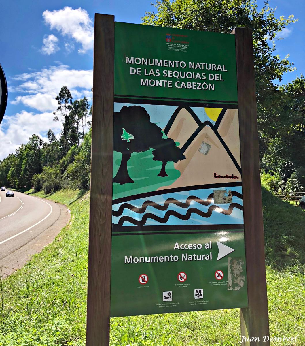 Cartel informativo y aparcamiento de tierra a la entrada del Monumento Natural de las Secuoyas, junto a la carretera CA-135.