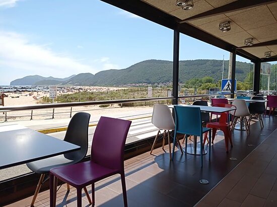 Terraza de Bitácora en el Paseo de Trengandín (Noja), mesas frente a la playa al atardecer