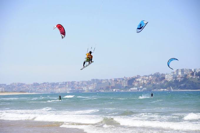 Playa de Somo a la entrada de la bahía de Santander, con practicantes de kitesurf en el agua