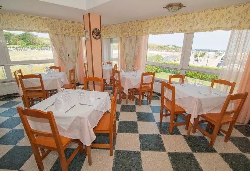 Comedor del Hotel Costa de Ajo con vistas al mar y zona de juegos infantil visible.
