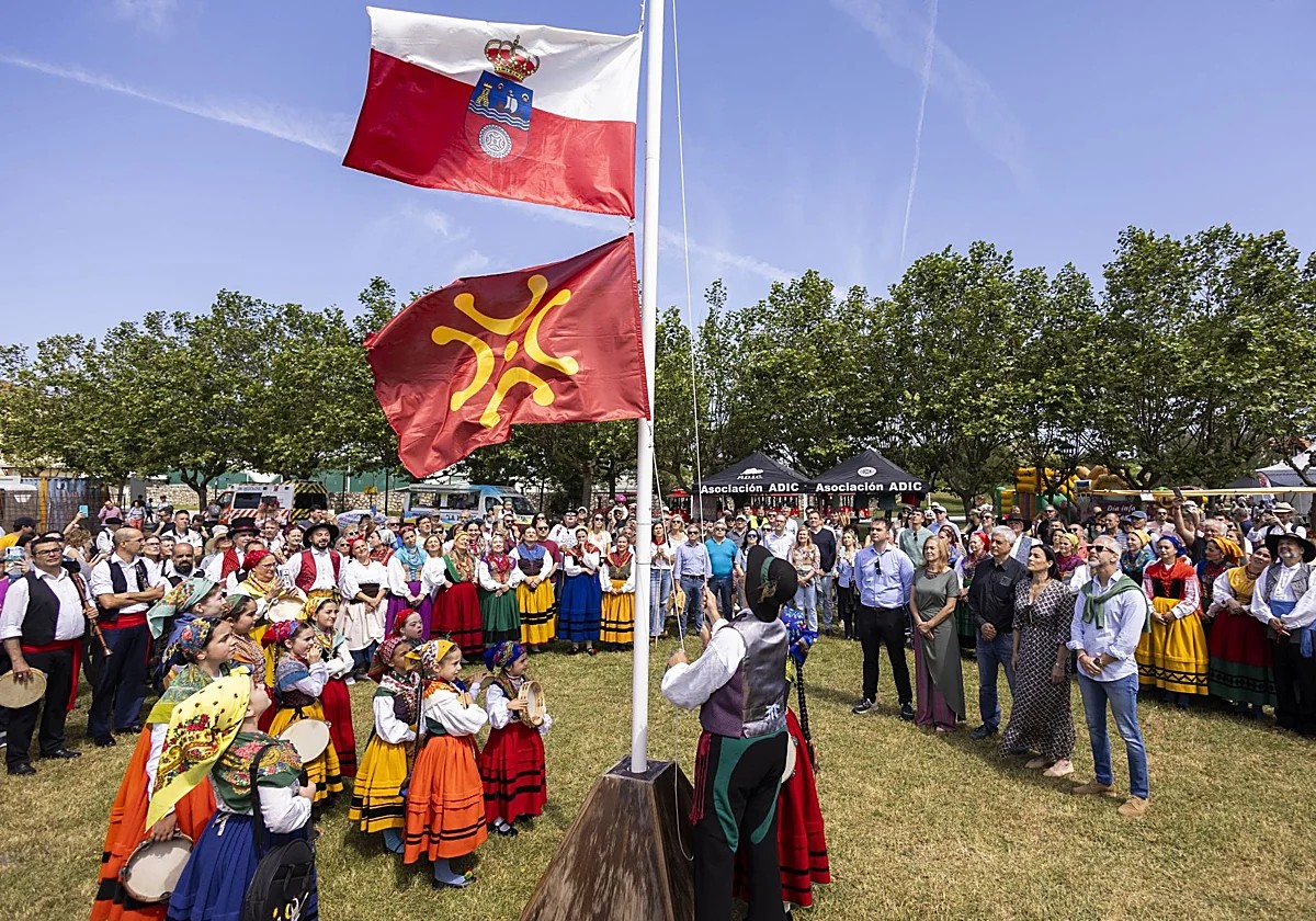 Ambiente de fiesta popular en la plaza de un pueblo de Cantabria, banderines y gente durante el día