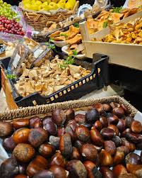 Puesto de mercado tradicional cántabro con castañas, setas y productos de temporada de otoño.