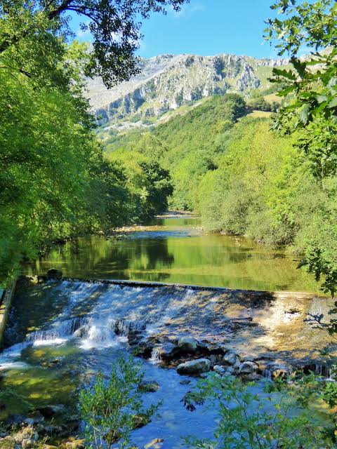 Primer plano del cauce del río Asón con caudal bajo en un día seco de otoño, contraste con la roca caliza.