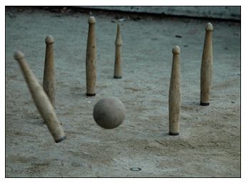Exhibición de bolos cántabros durante una fiesta patronal, público alrededor de la bolera